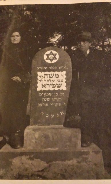 Bella and
                Hershel Shapiro at gravestone of Moshe Shapiro.